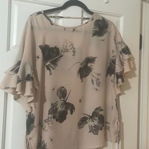 Light pink sheer blouse with black flower detail and v back. Side tie details